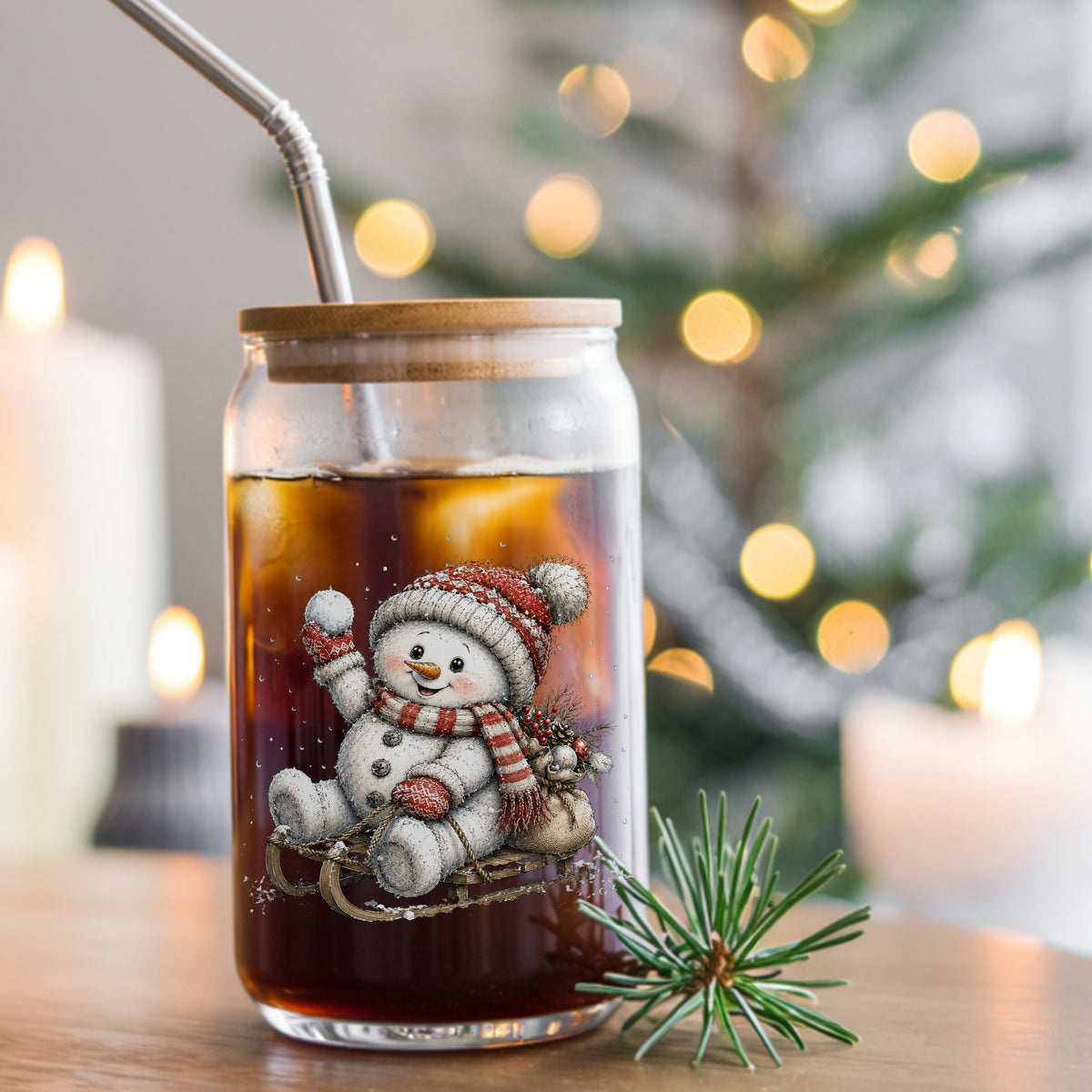 Snowball Snowman On Sled UV DTF sticker applied to a glass can cup of iced coffee with a straw