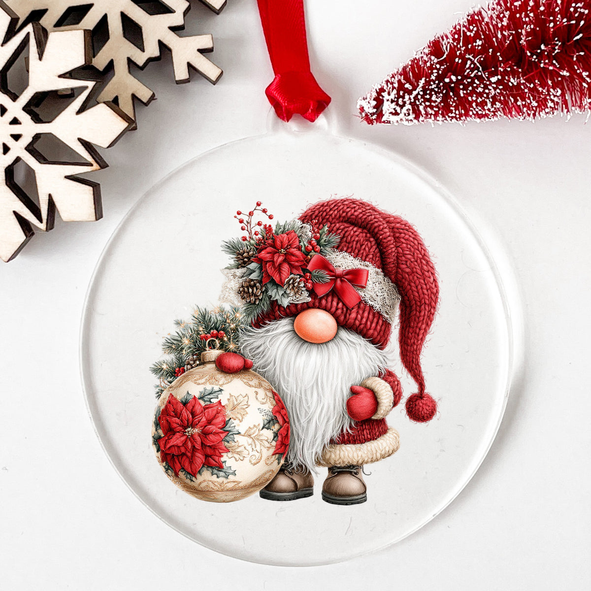 Christmas Gnome With Poinsettia Ornament UV DTF sticker applied to a clear round acrylic ornament with a red ribbon