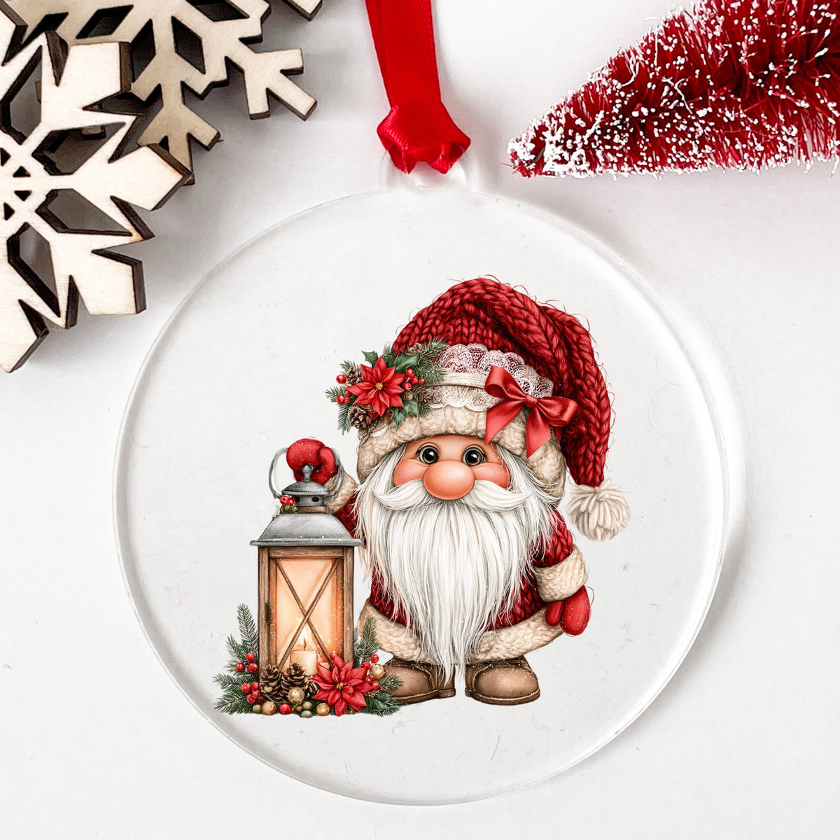 Gnome With Glowing Lantern UV DTF sticker applied to a clear round acrylic ornament with a red ribbon