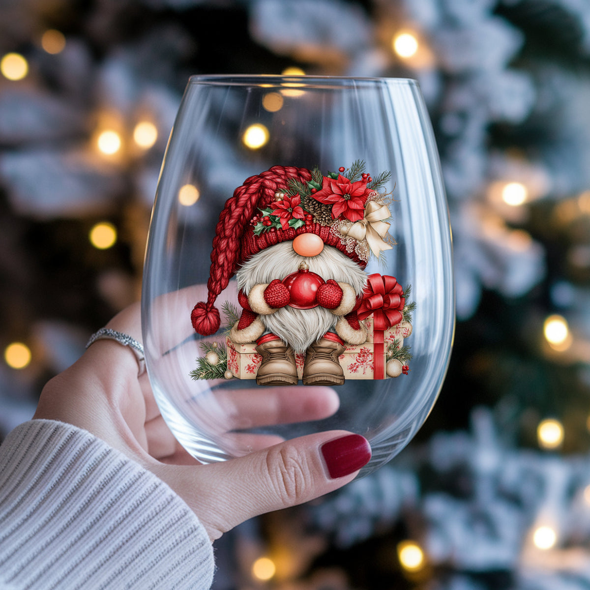 Gnome Holding Red Ornament UV DTF sticker applied to a stemless wine glass held in hand
