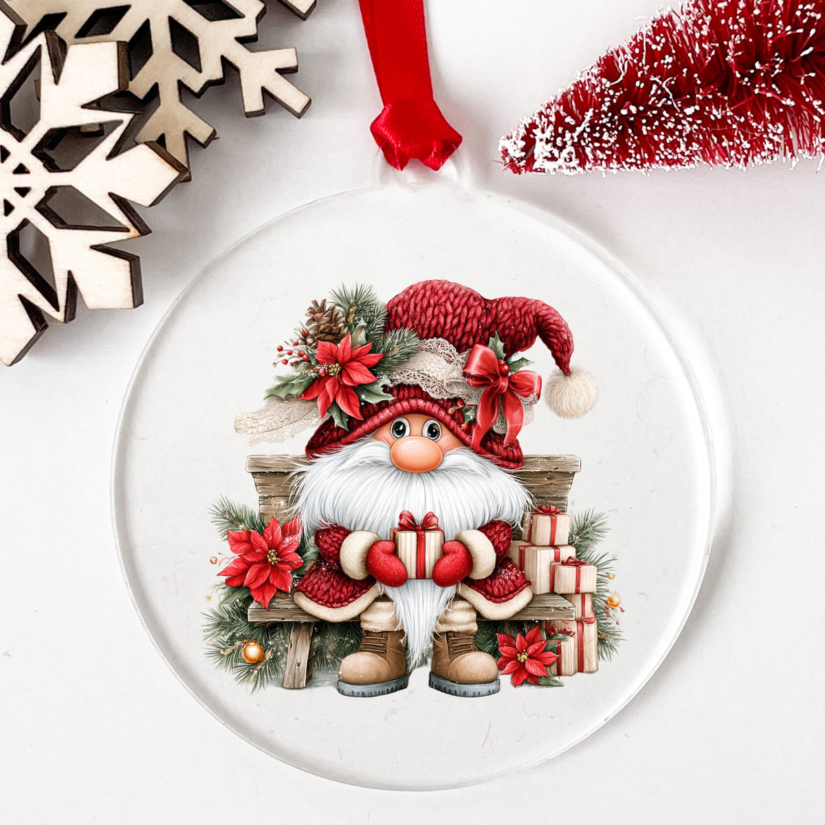 Gnome On Wooden Bench With Gifts UV DTF sticker applied to a clear round acrylic ornament with a red ribbon