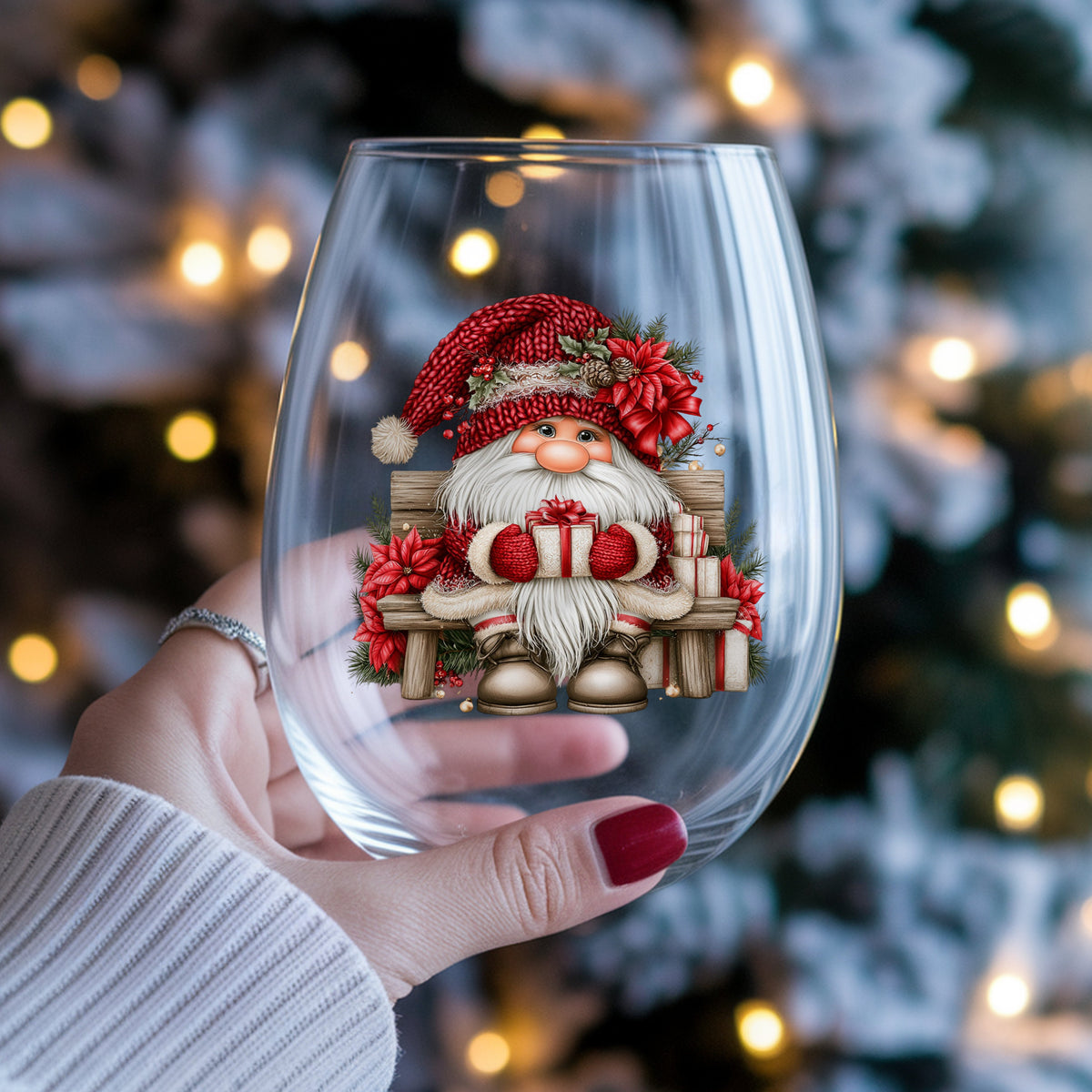 Gnome Sitting On Bench With Poinsettias UV DTF sticker applied to a stemless wine glass held in hand