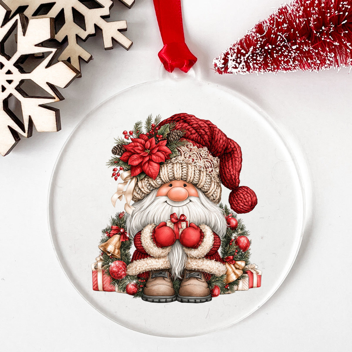 Gnome With Gold Bells And Cream Hat UV DTF sticker applied to a clear round acrylic ornament with a red ribbon