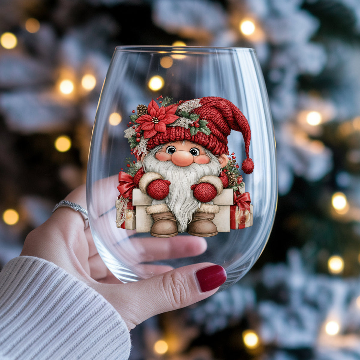 Gnome Sitting On Gift Boxes UV DTF sticker applied to a stemless wine glass held in hand