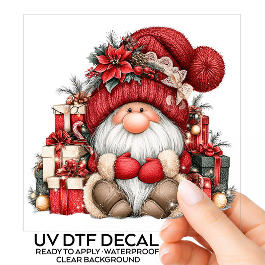 Gnome With Pile Of Presents UV DTF sticker on its backing card, held in hand