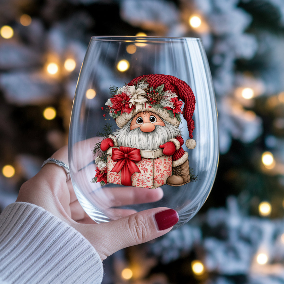 Gnome Peeking From Gift Box UV DTF sticker applied to a stemless wine glass held in hand