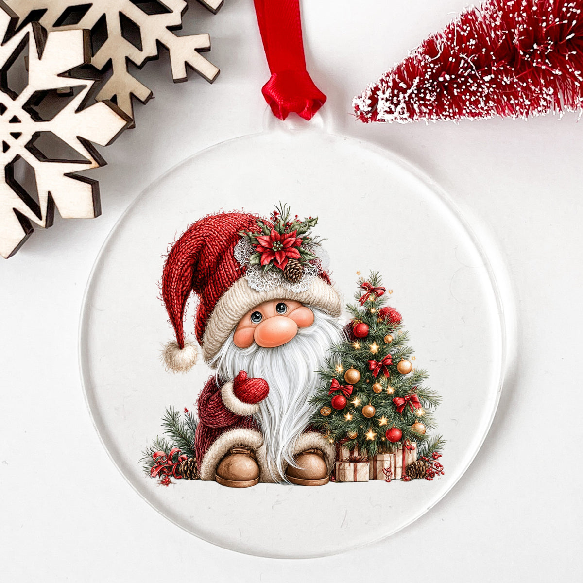 Gnome With Decorated Christmas Tree UV DTF sticker applied to a clear round acrylic ornament with a red ribbon