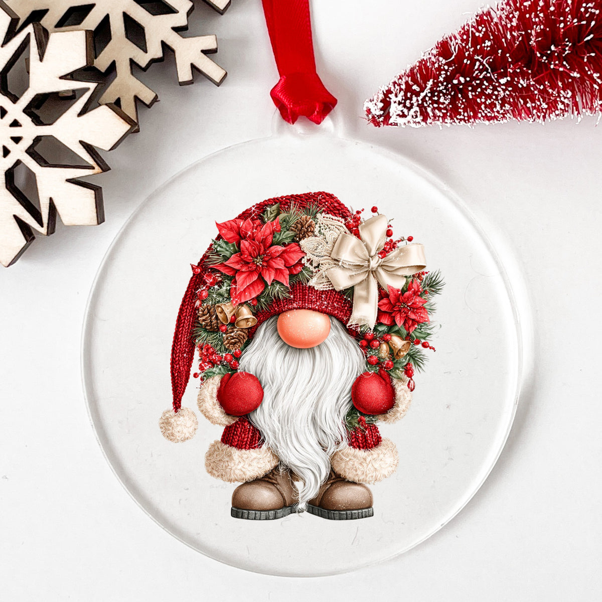 Scandinavian Gnome With Bells And Bow UV DTF sticker applied to a clear round acrylic ornament with a red ribbon