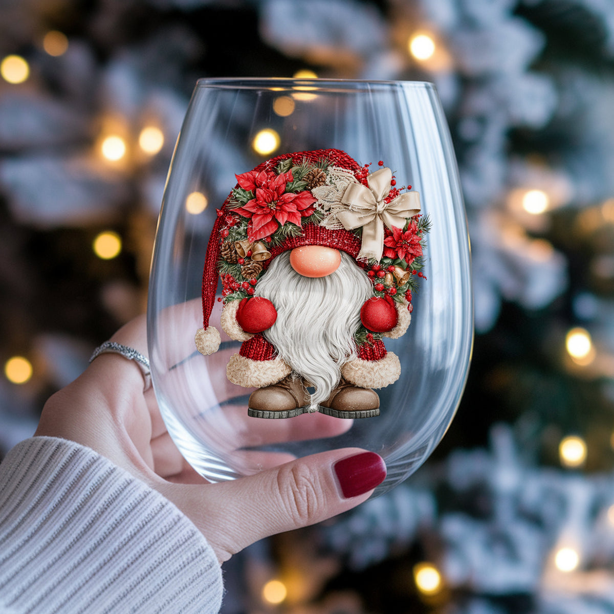 Scandinavian Gnome With Bells And Bow UV DTF sticker applied to a stemless wine glass held in hand