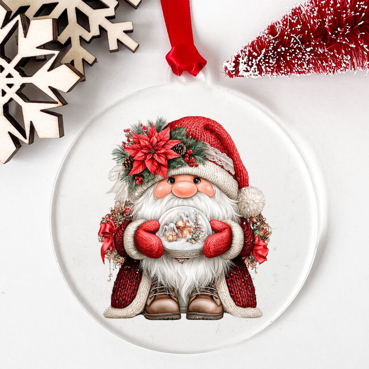 Gnome Holding Snow Globe UV DTF sticker applied to a clear round acrylic ornament with a red ribbon