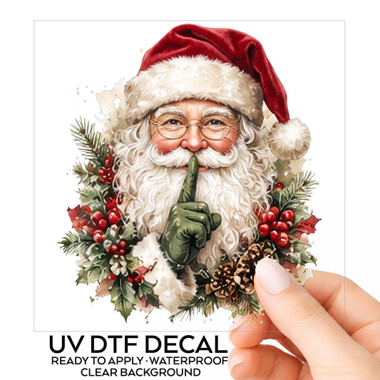 Shush Santa Claus With Holly UV DTF sticker on its backing card, held in hand