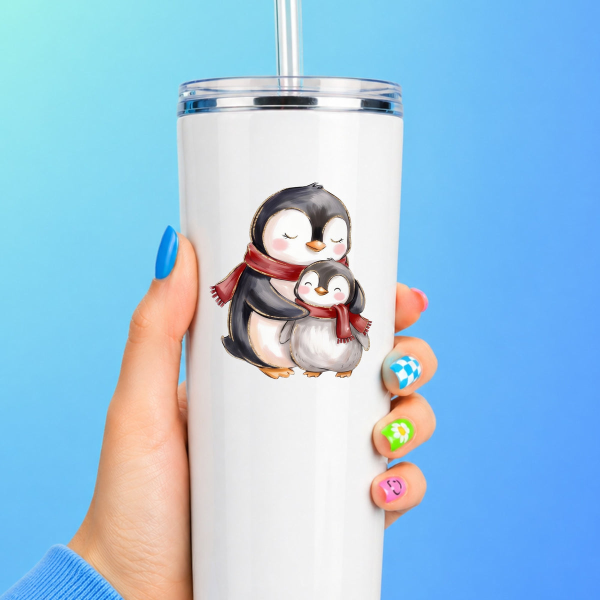 Mama And Baby Penguin In Red Scarves UV DTF sticker applied to a white straw tumbler on a blue background