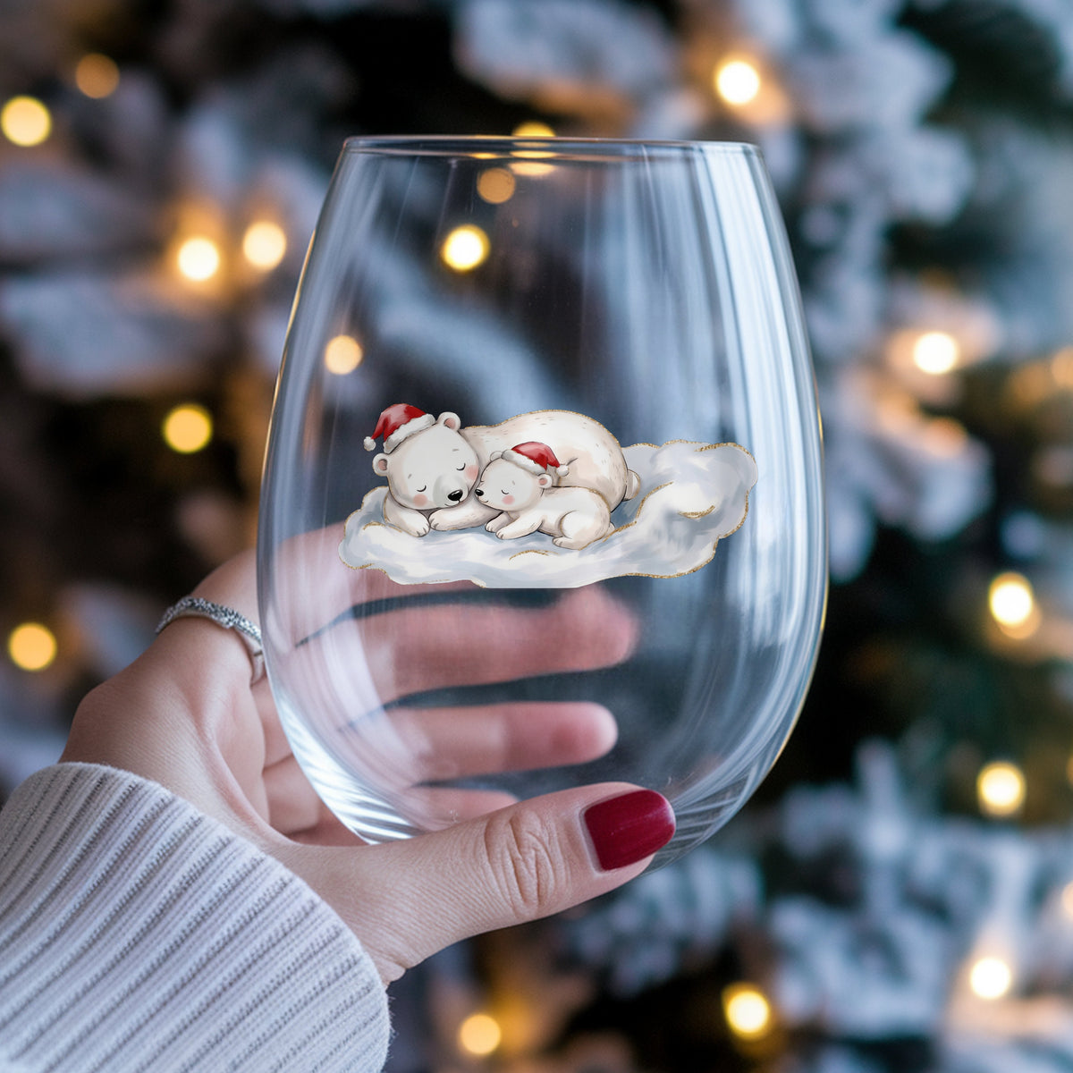 Sleeping Polar Bear And Cub In Santa Hats UV DTF sticker applied to a stemless wine glass held in hand
