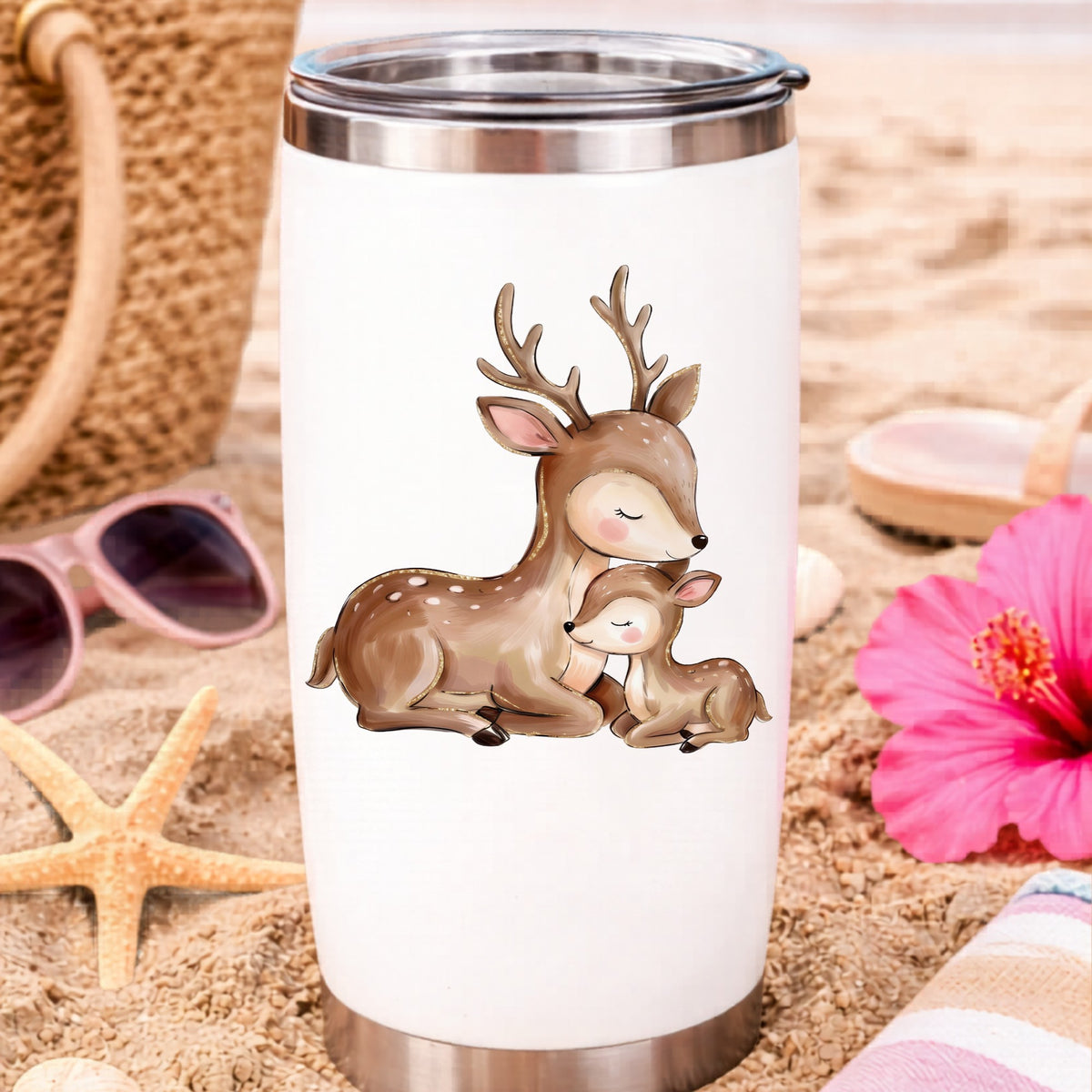 Mother Deer And Fawn UV DTF sticker applied to a white travel tumbler on beach sand