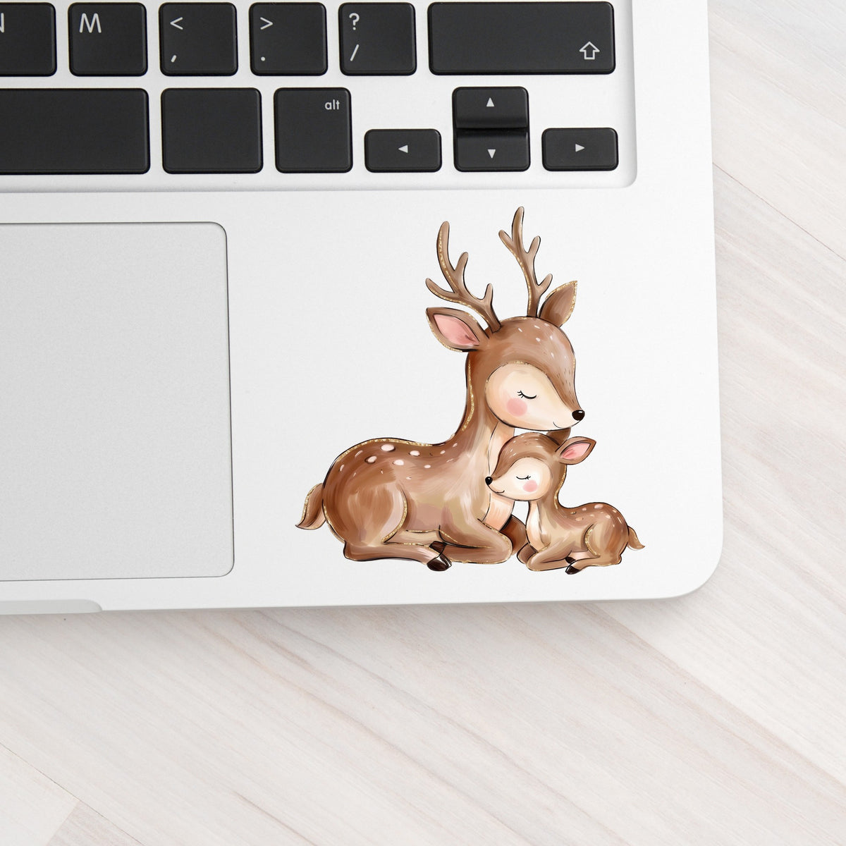 Mother Deer And Fawn UV DTF sticker applied to a silver laptop beside the keyboard
