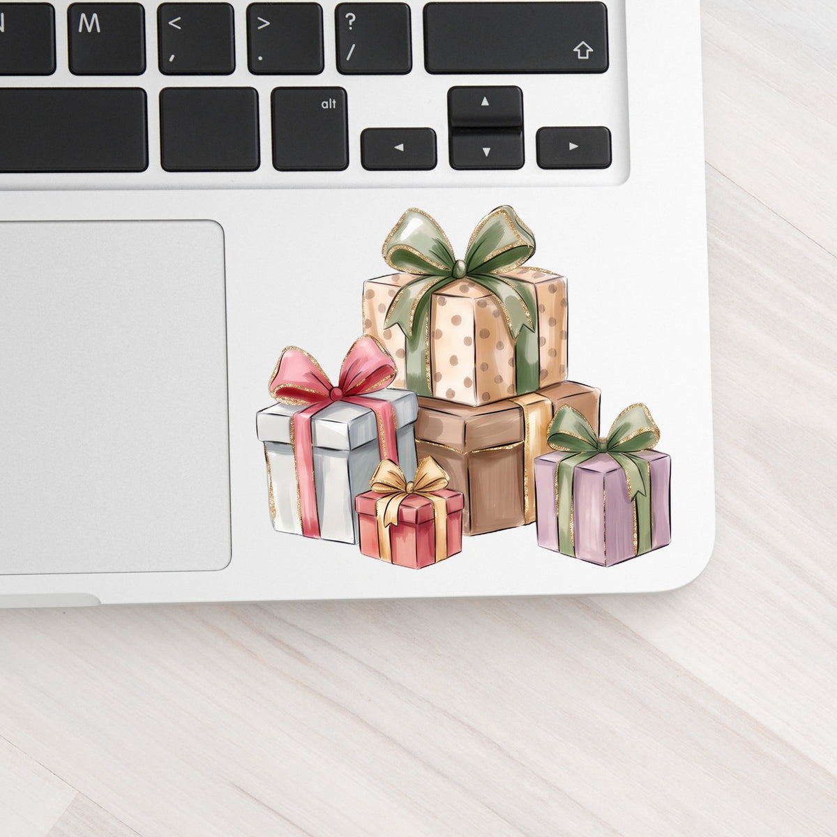 Pastel Gift Box Stack UV DTF sticker applied to a silver laptop beside the keyboard