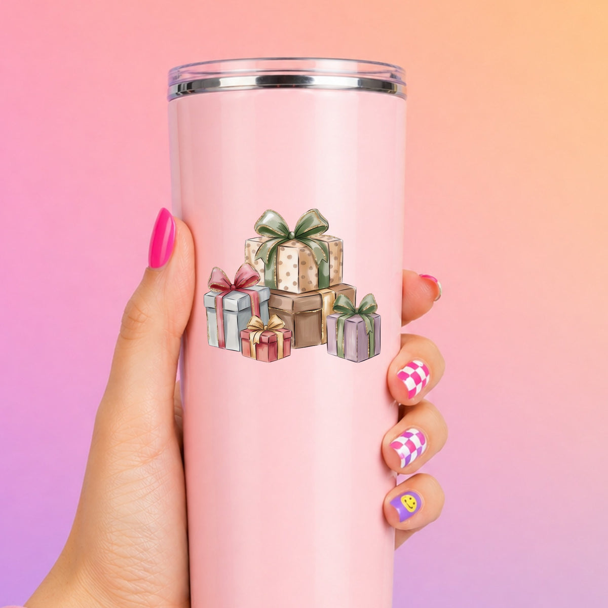 Pastel Gift Box Stack UV DTF sticker applied to a tall pink tumbler on a pink and orange background