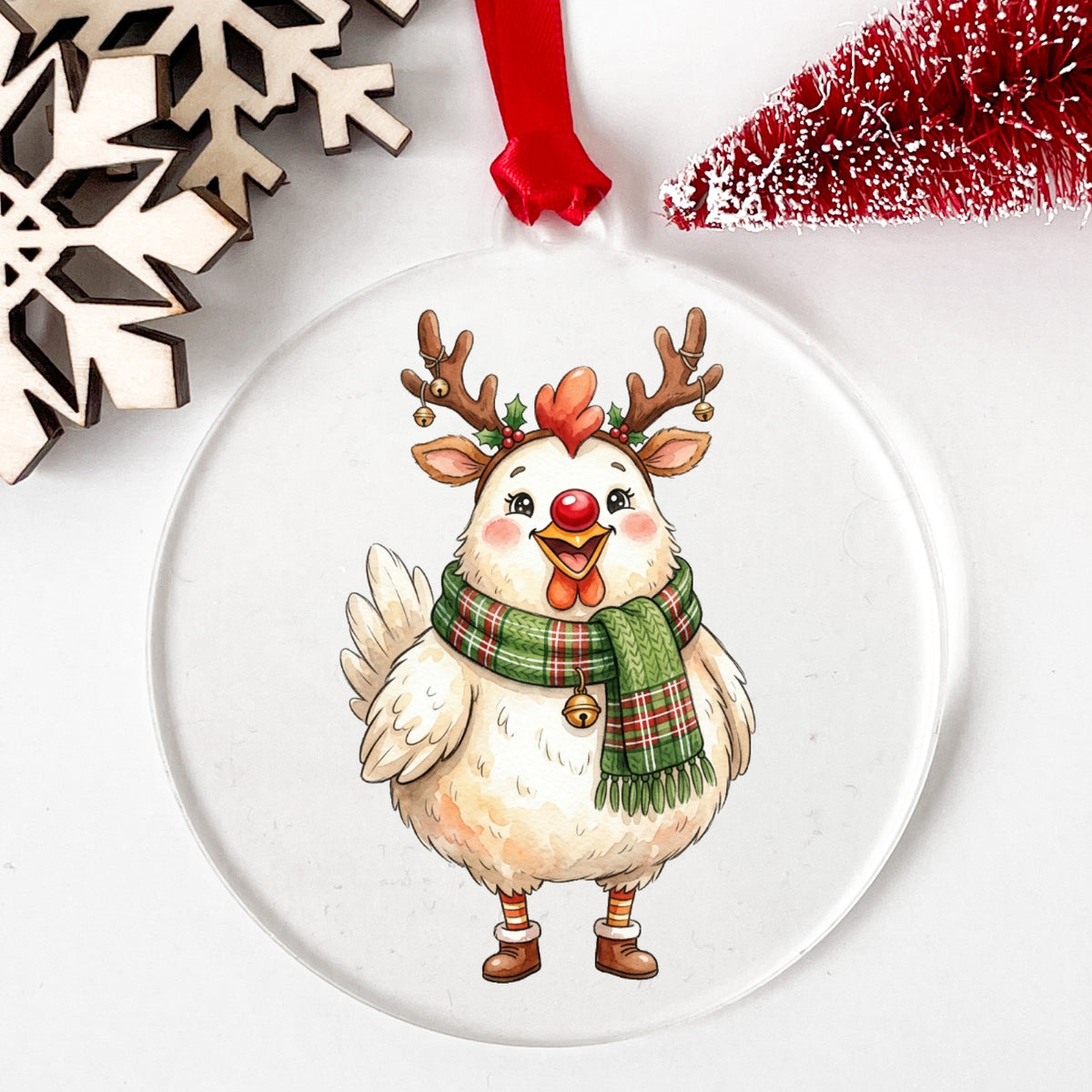Reindeer Antler Chicken With Red Nose UV DTF sticker applied to a clear round acrylic ornament with a red ribbon