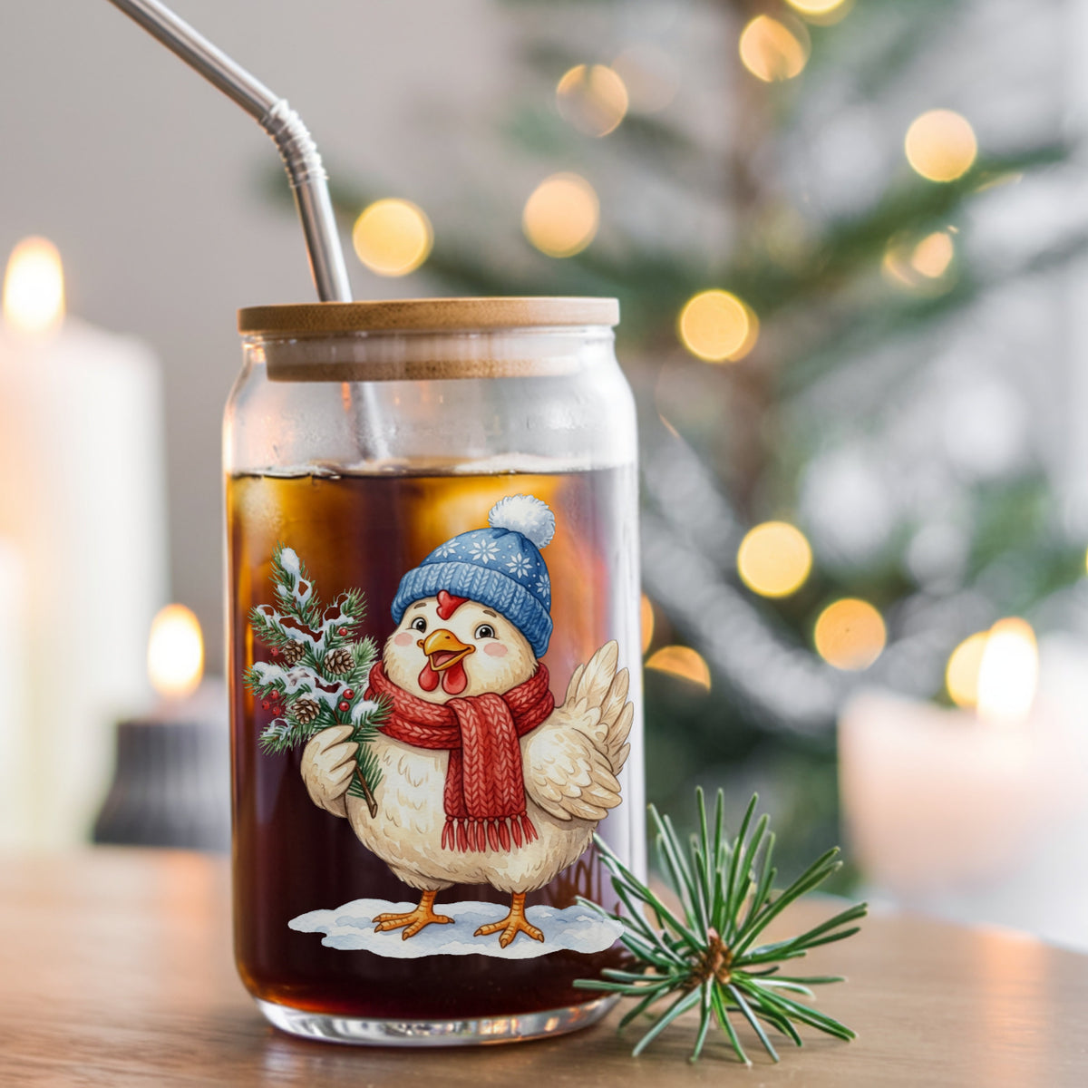 Blue Beanie Chicken With Pine Branch UV DTF sticker applied to a glass can cup of iced coffee with a straw