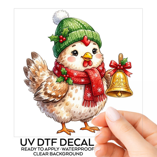 Chicken Holding Gold Jingle Bell UV DTF sticker on its backing card, held in hand
