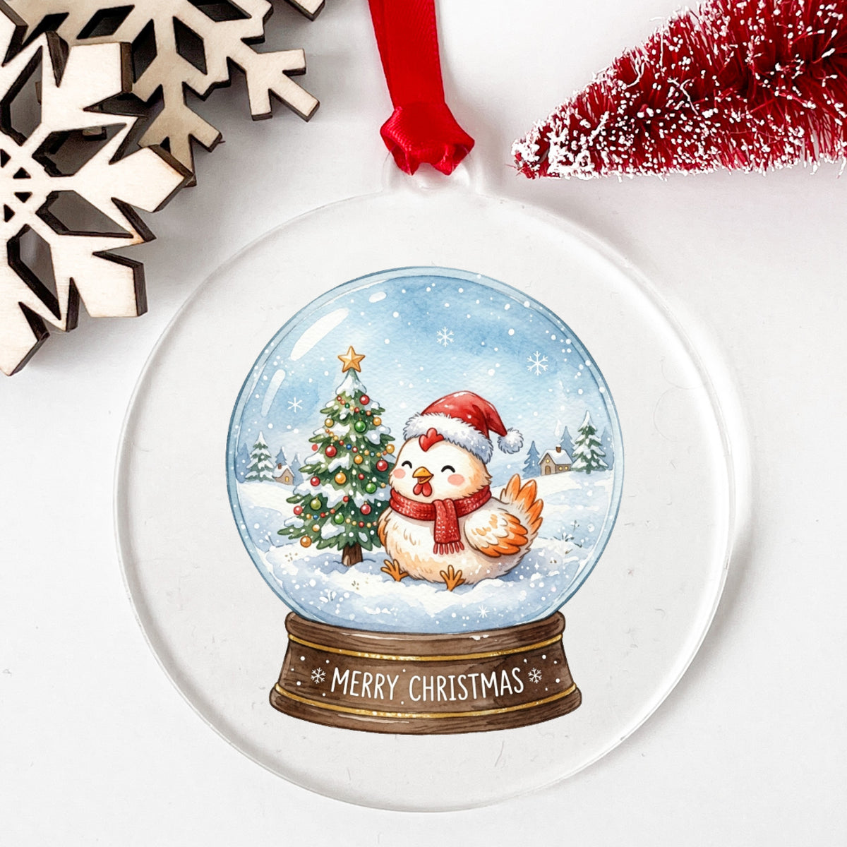Merry Christmas Snow Globe Chicken UV DTF sticker applied to a clear round acrylic ornament with a red ribbon