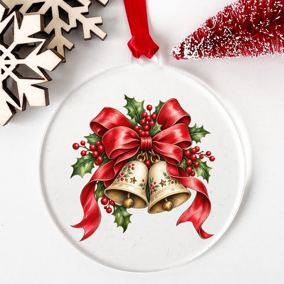 Christmas Bells With Red Bow UV DTF sticker applied to a clear round acrylic ornament with a red ribbon