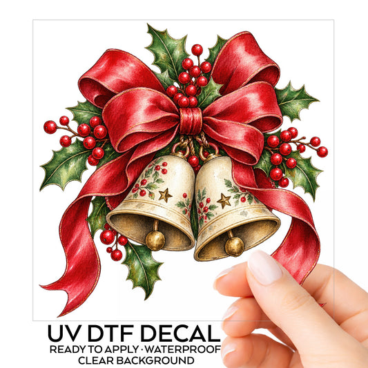 Christmas Bells With Red Bow UV DTF sticker on its backing card, held in hand