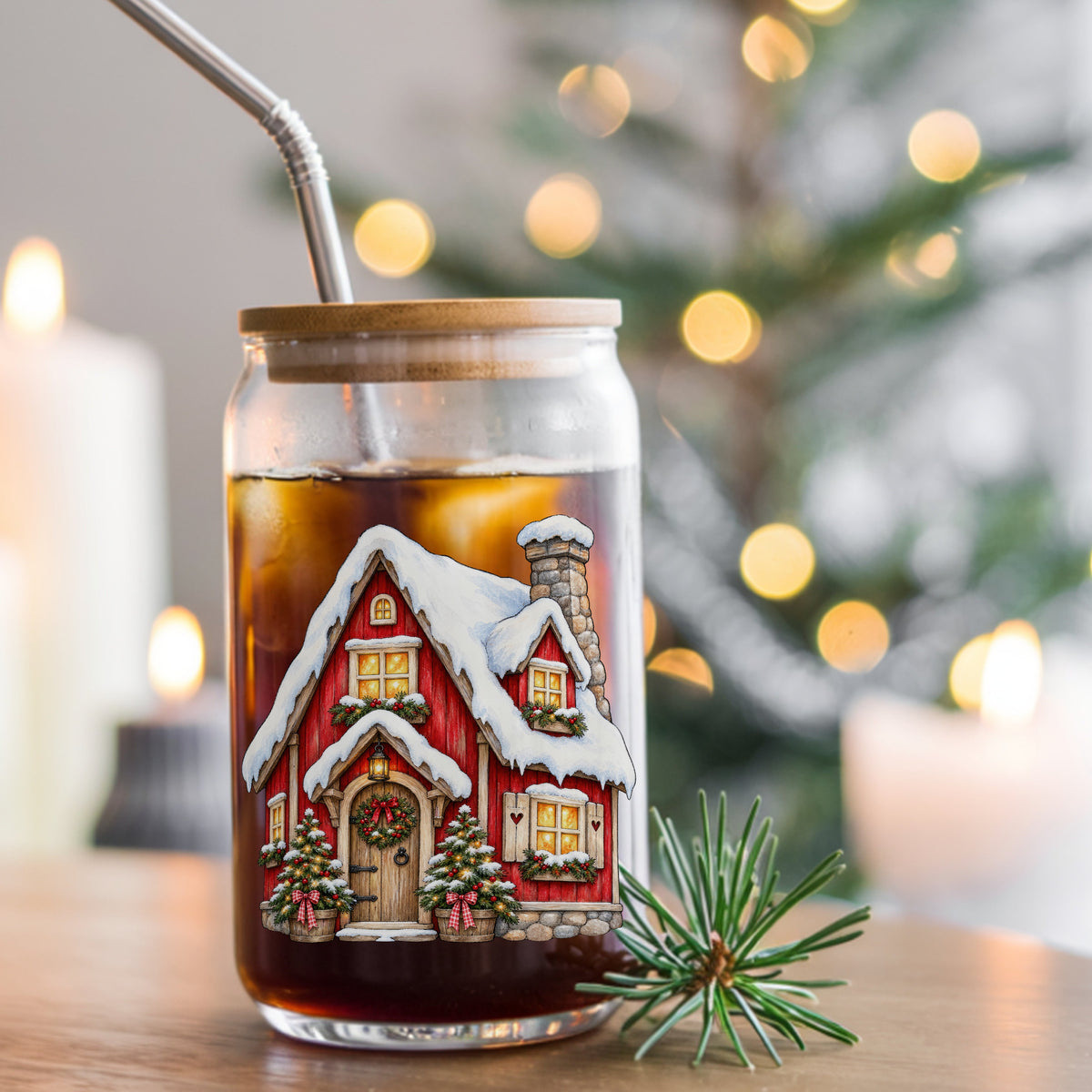 Red Christmas Cottage In Snow UV DTF sticker applied to a glass can cup of iced coffee with a straw