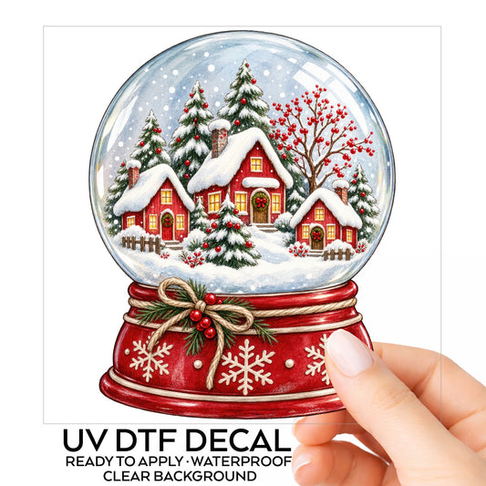 Christmas Village Snow Globe UV DTF sticker on its backing card, held in hand