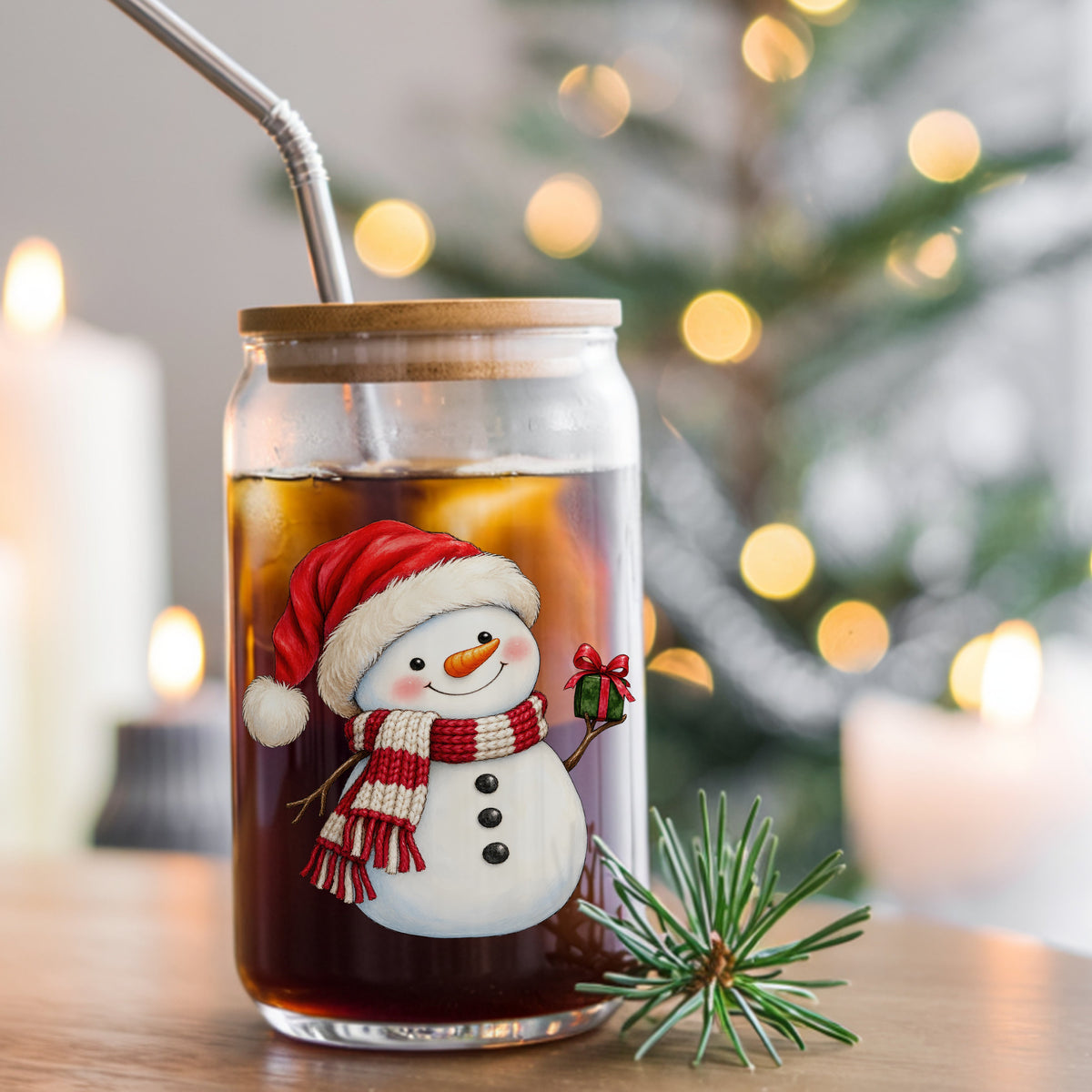 Snowman In Santa Hat With Gift UV DTF sticker applied to a glass can cup of iced coffee with a straw
