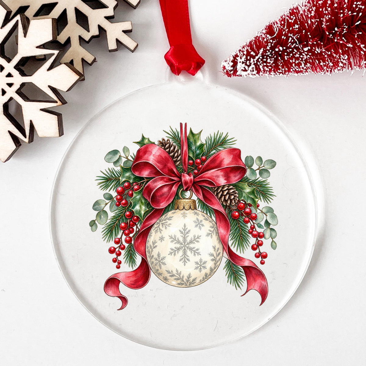 Snowflake Ornament With Red Bow UV DTF sticker applied to a clear round acrylic ornament with a red ribbon