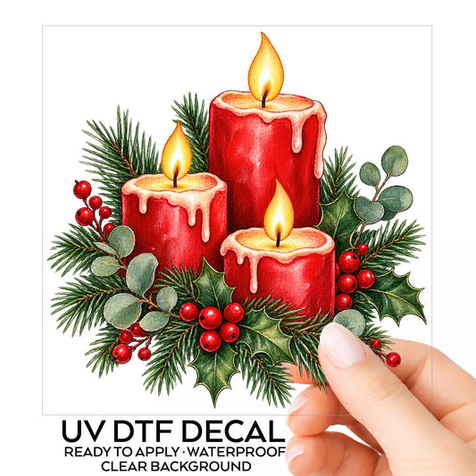 Red Christmas Candles With Greenery UV DTF sticker on its backing card, held in hand