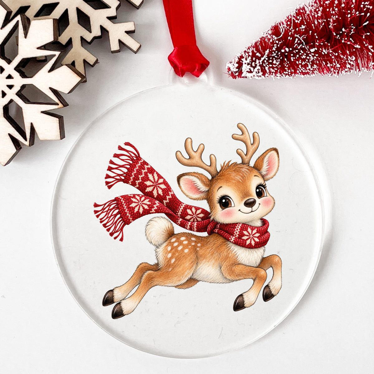 Leaping Reindeer In Nordic Scarf UV DTF sticker applied to a clear round acrylic ornament with a red ribbon