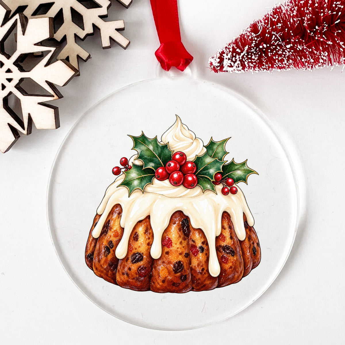 Christmas Fruitcake Bundt With Holly UV DTF sticker applied to a clear round acrylic ornament with a red ribbon