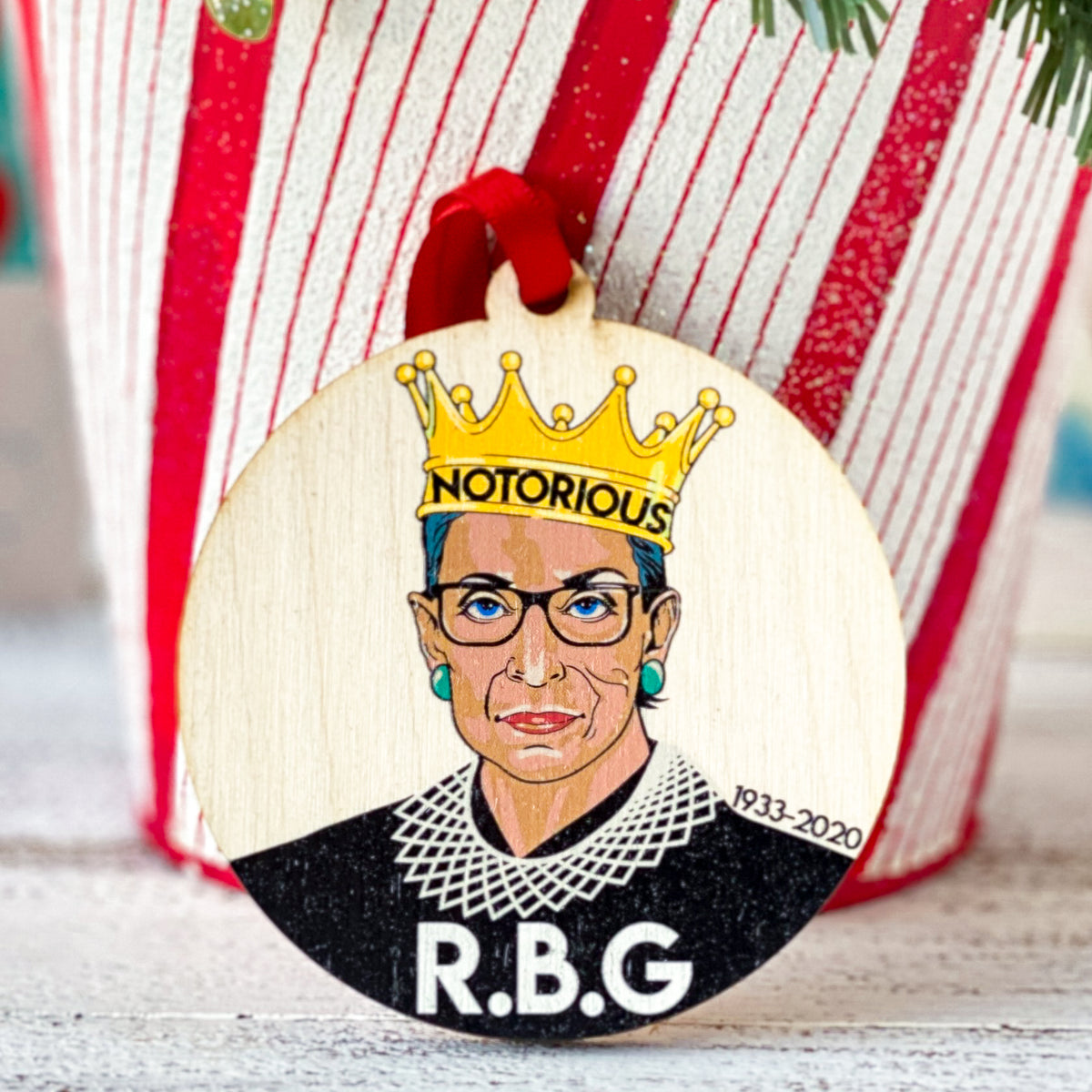round wooden ornament with a crowned Ruth Bader Ginsburg saying Notorious RBG 1933-2020