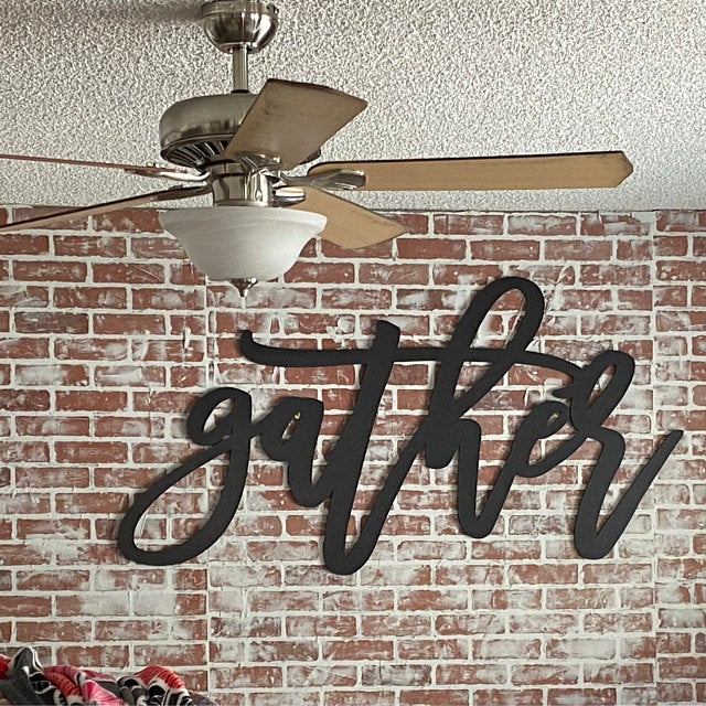 gather sign on brick wall